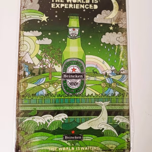 Metalen Bord Heineken The World Is Waiting met groene Heineken fles en kleurrijke achtergrond